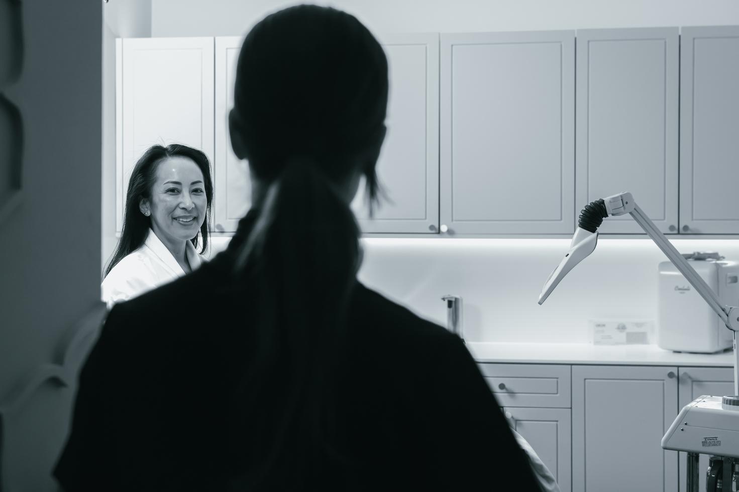 A client is walking into a room for a service, the provider is facing with their back to the screen.