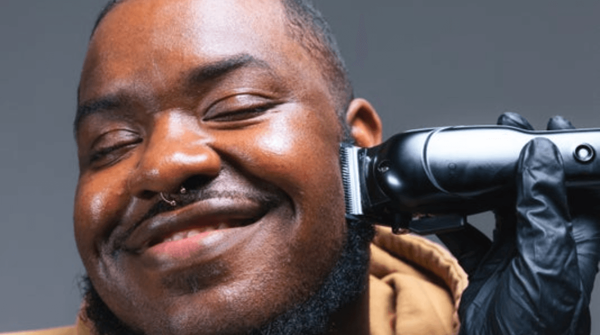 A man gets a close shave at a barbershop.