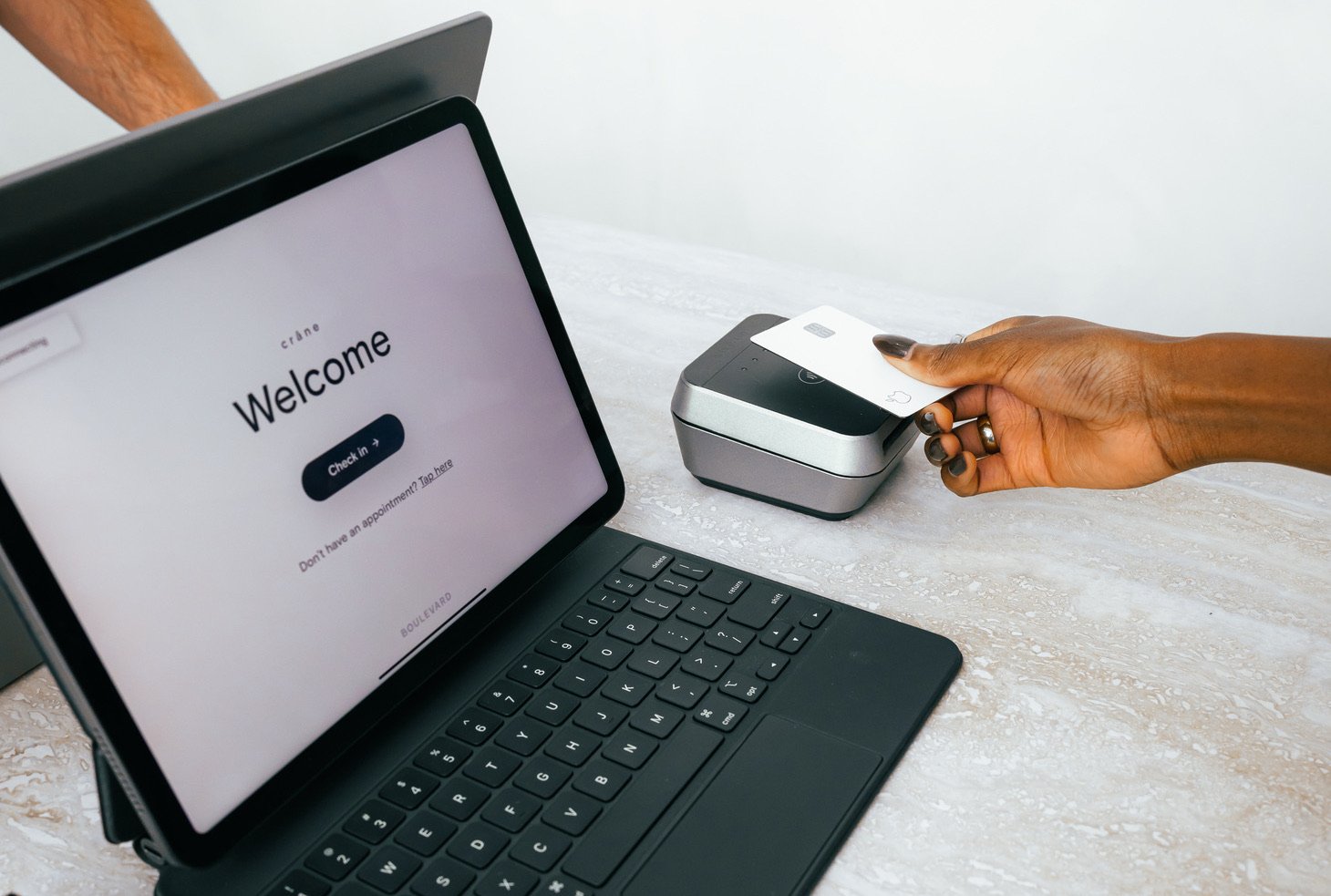 A customer uses their tap-to-pay credit card on a handheld point of sale device.