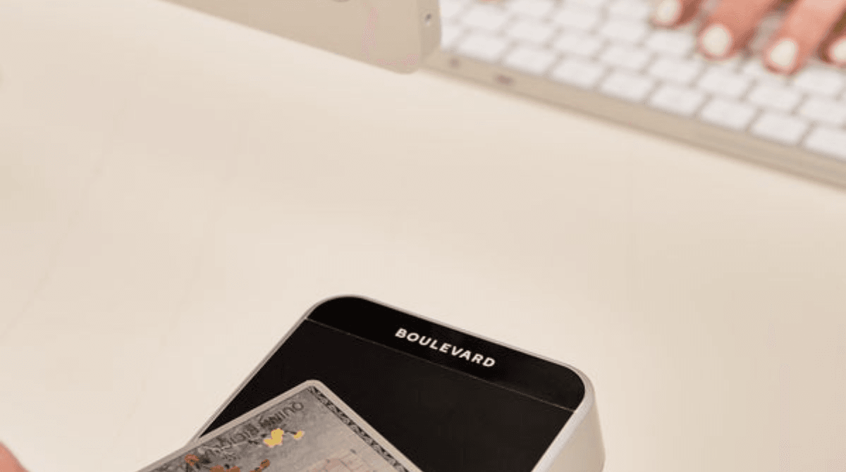 A client taps a credit card against a Boulevard Duo payment processing device at checkout.