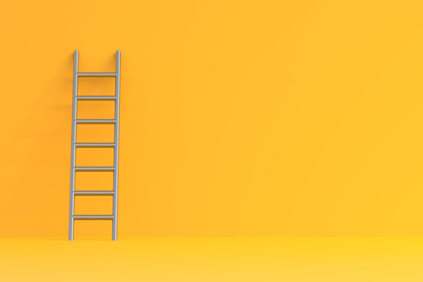 A stainless steel ladder is propped up against a yellow wall.