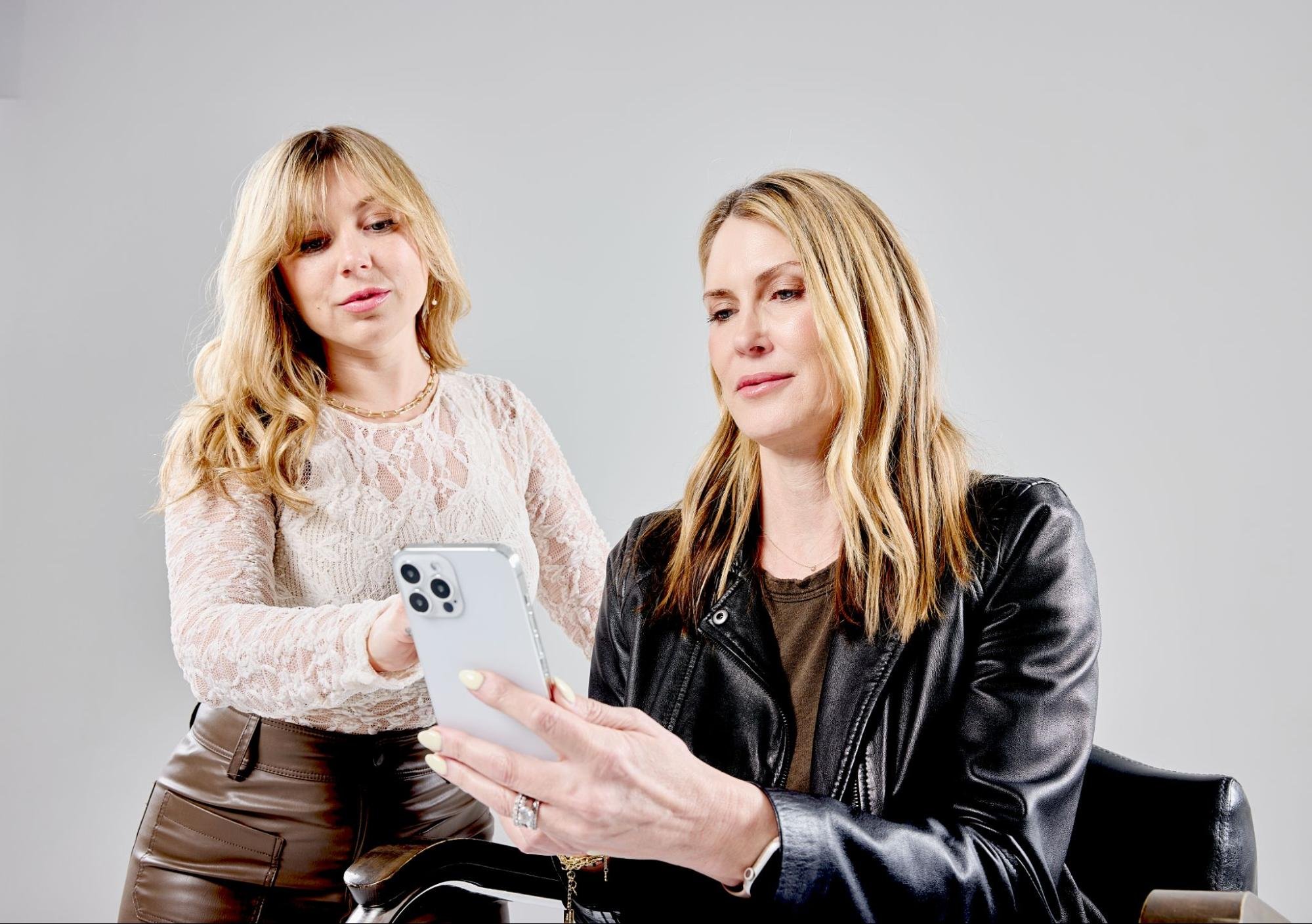 Two women looking at a smartphone.