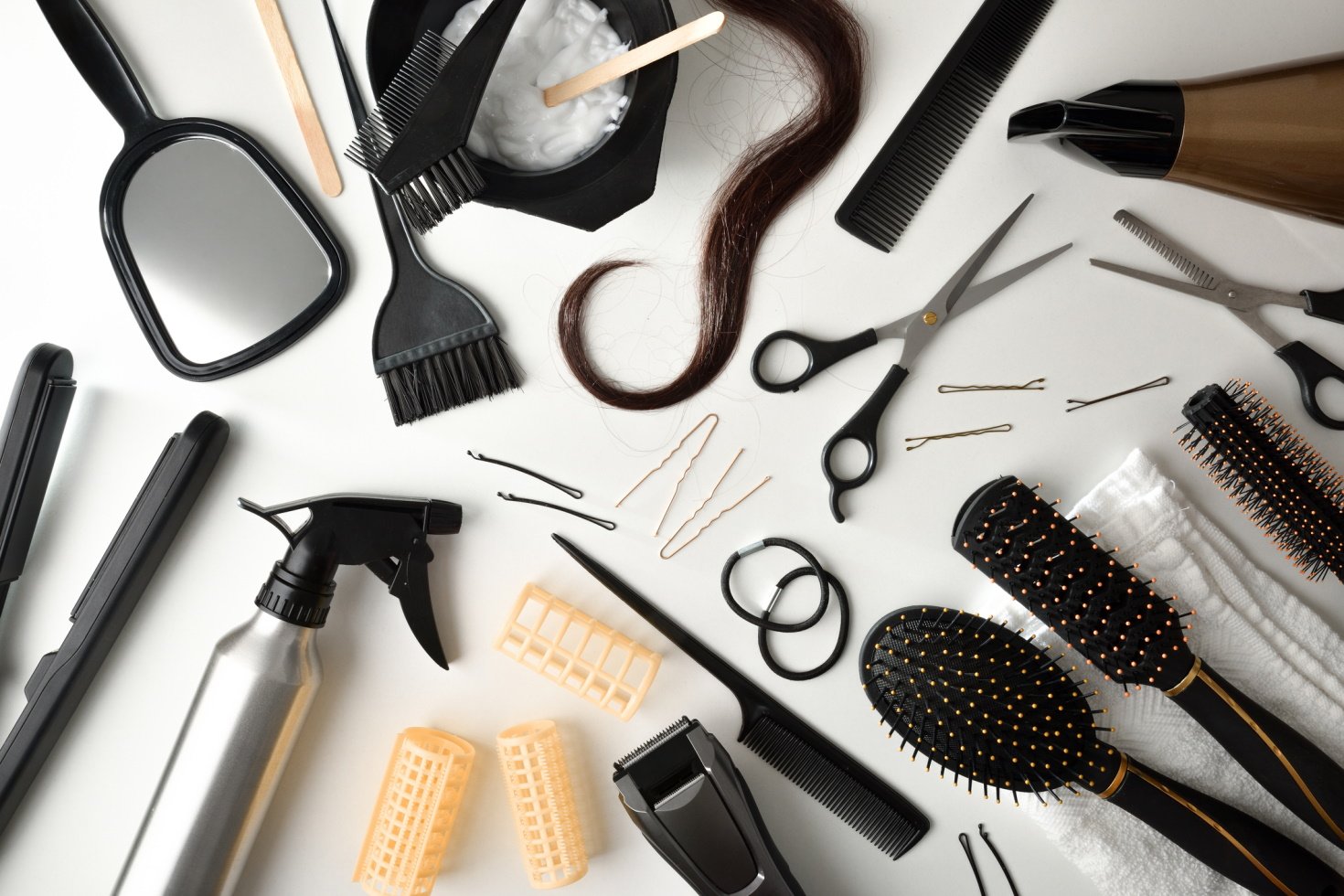 Set of tools for hair cutting and styling on white table. Top view. Horizontal composition.