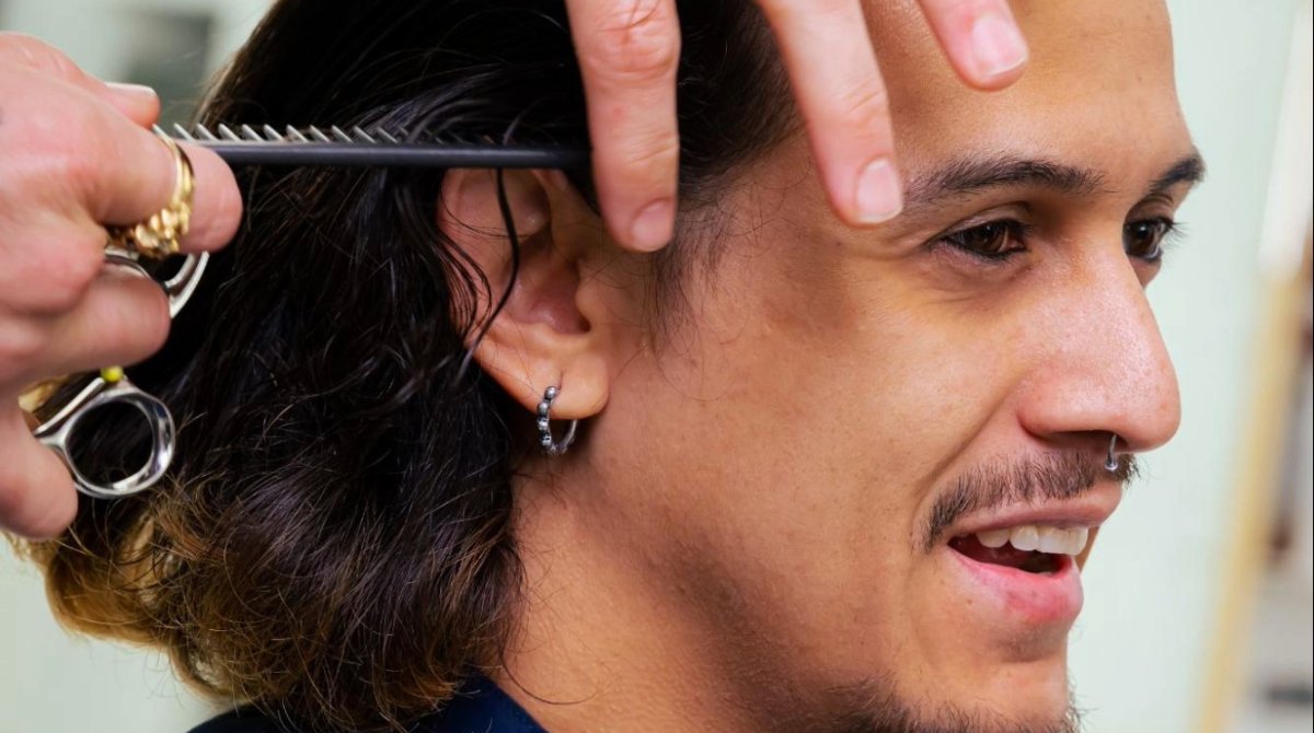 A barbershop client receives a haircut.