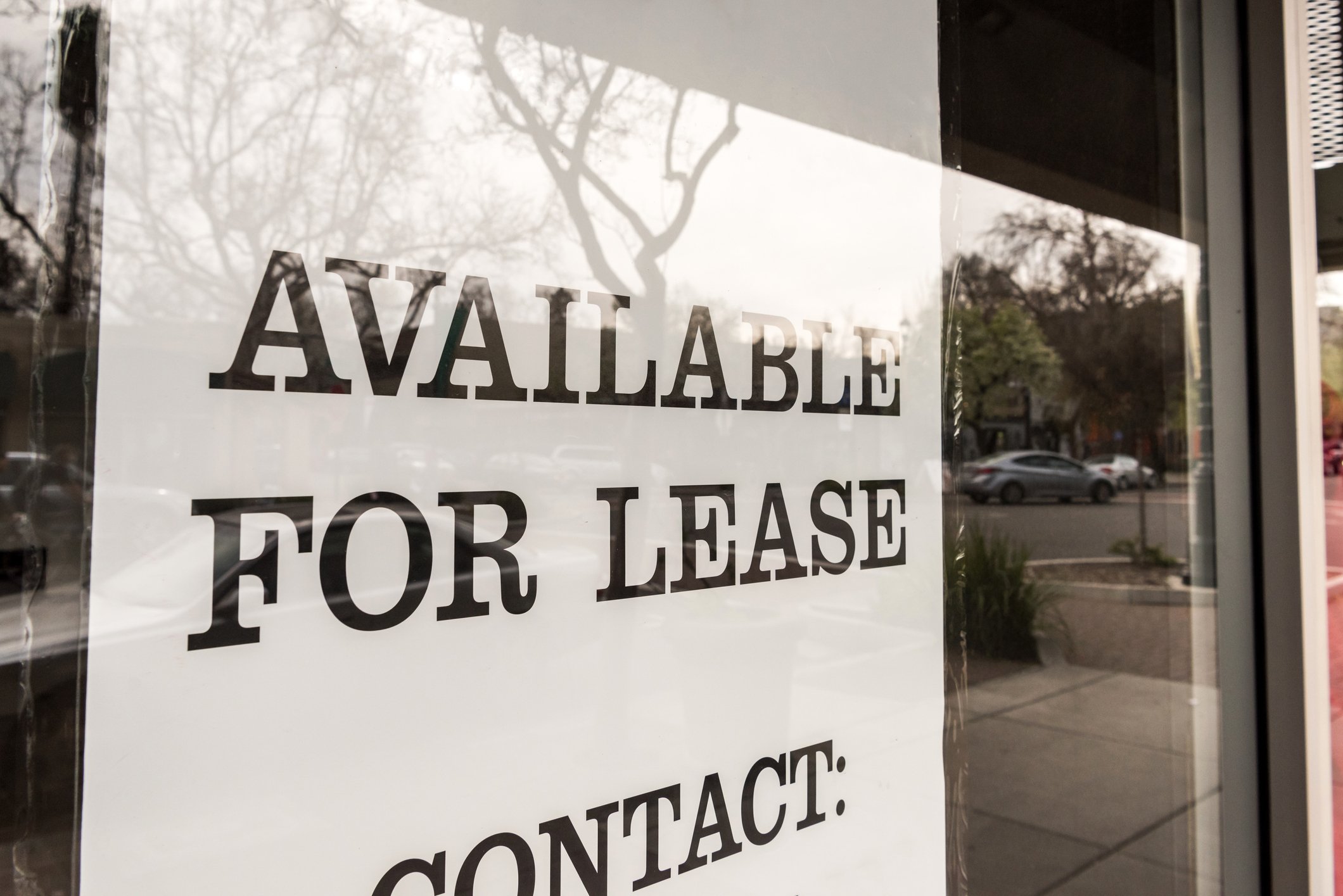 A sign in a window reads, "Available for lease. Contact:"