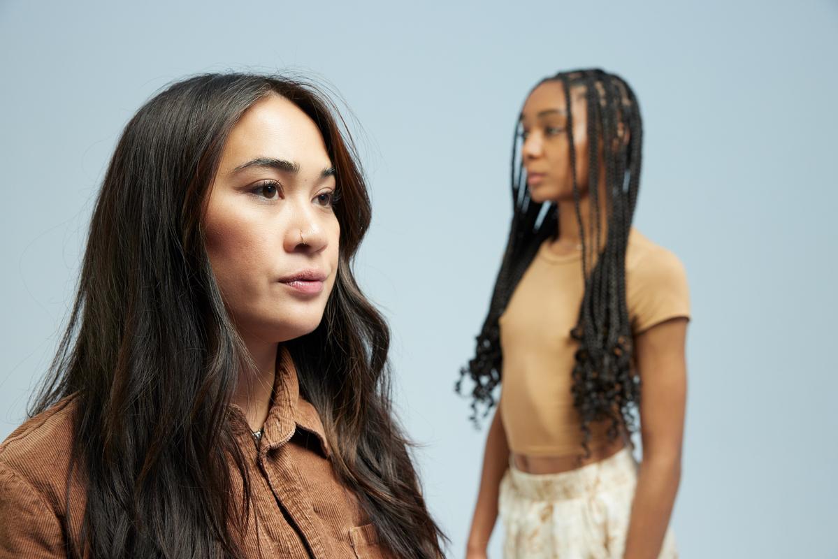 Two gen-z self-care clients facing the opposite direction, staring into the distance.